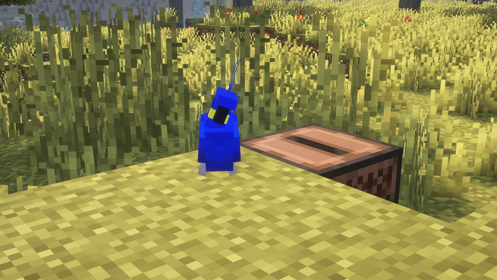 A blue parrot dancing next to a jukebox (Image via Mojang)